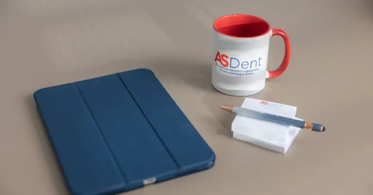ASDent-Tasse, Tablet und Notizblock auf dem Schreibtisch – GOÄ Ä1 in der Zahnarztpraxis richtig abrechnen